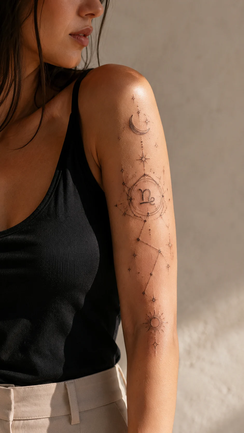Tatuagem astrológica elegante no pulso em ambiente luminoso.