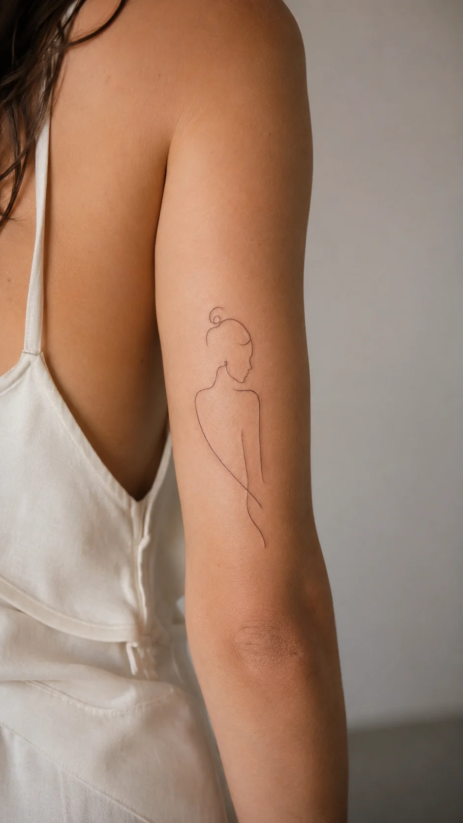 Braço com tatuagem composta por vários motivos discretos e harmoniosos.