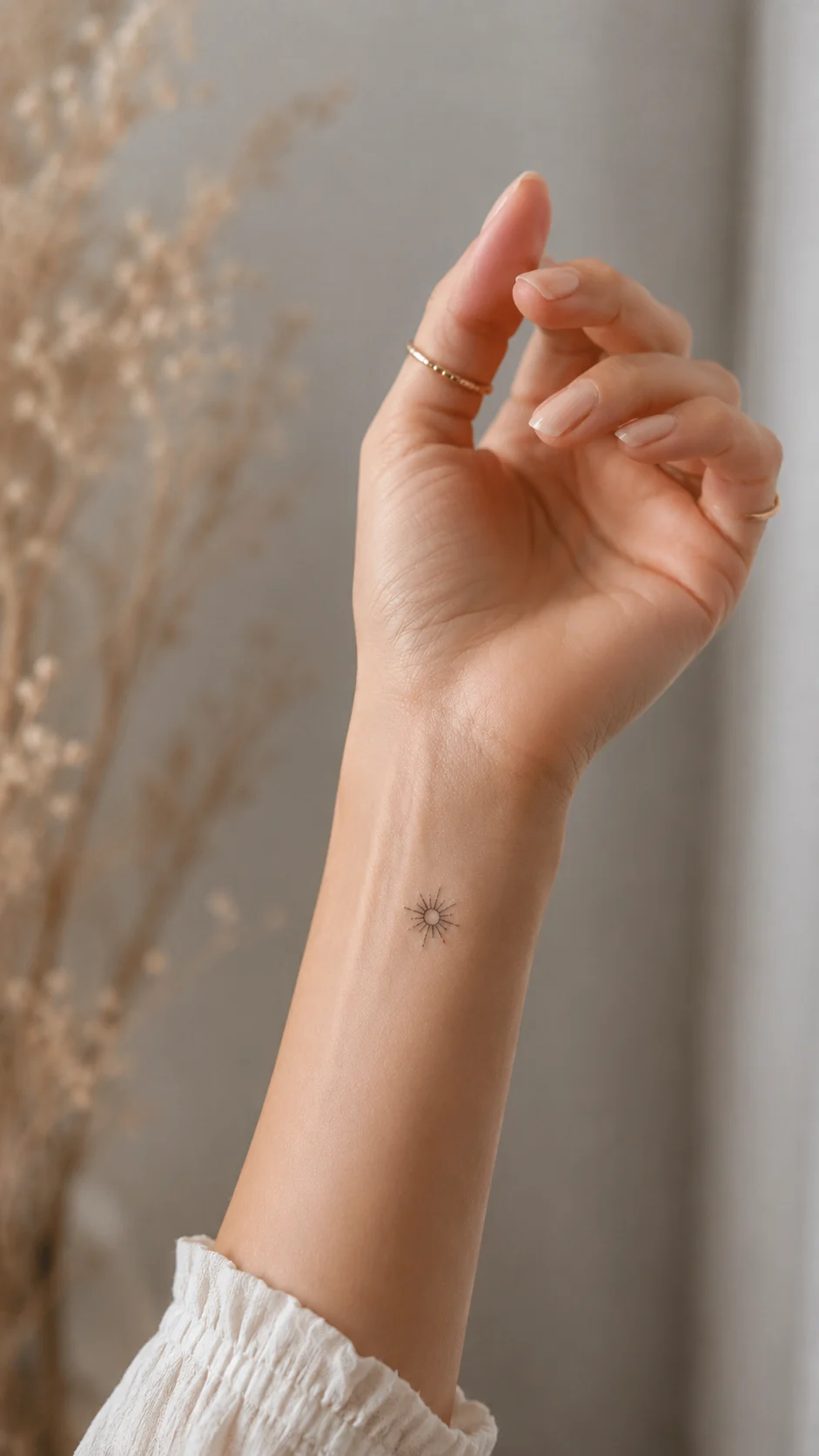 Close-up de um pulso com tatuagem de traço fino e aspeto minimalista.