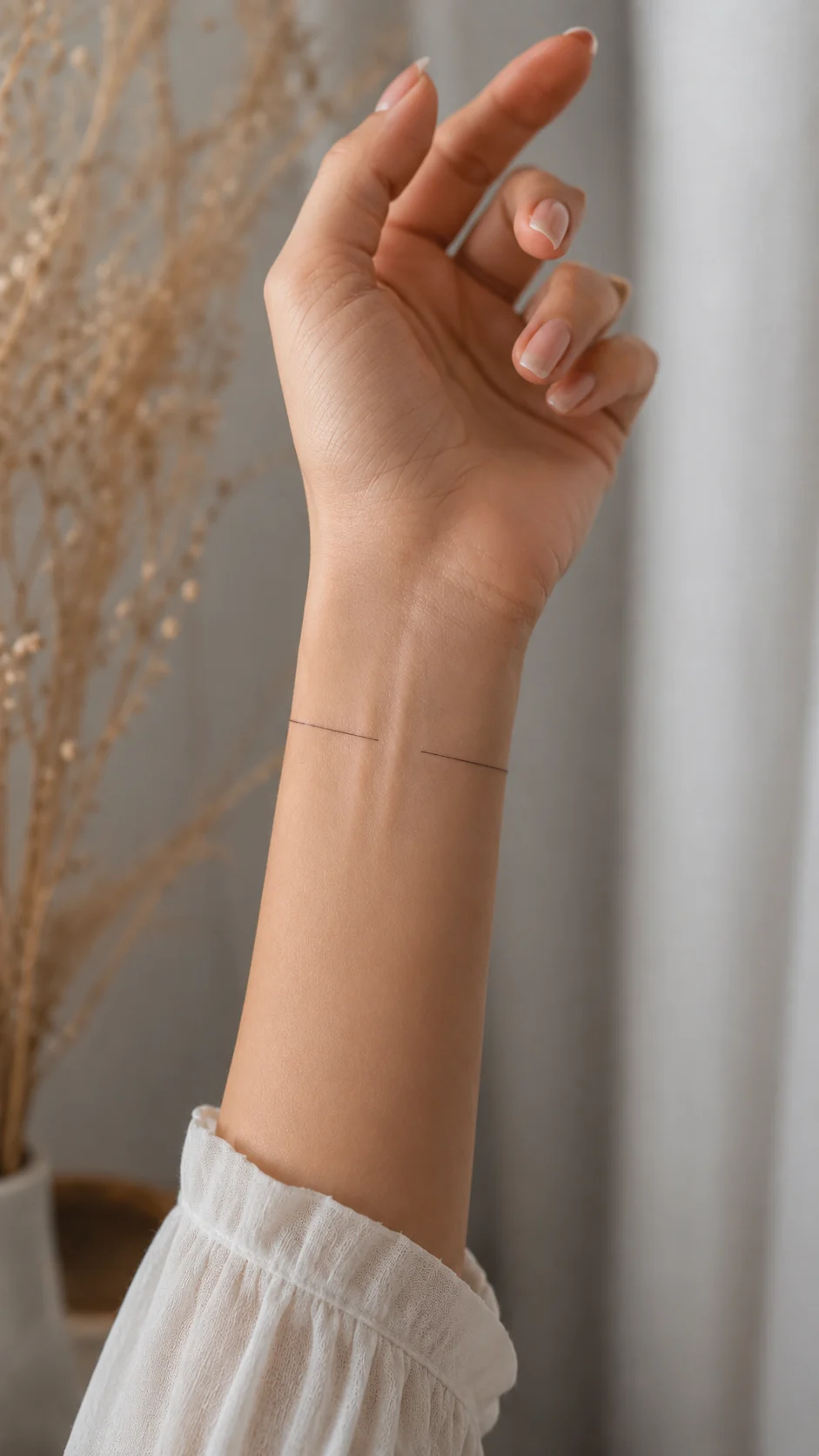 Pulso com uma pequena tatuagem floral discreta e feminina.