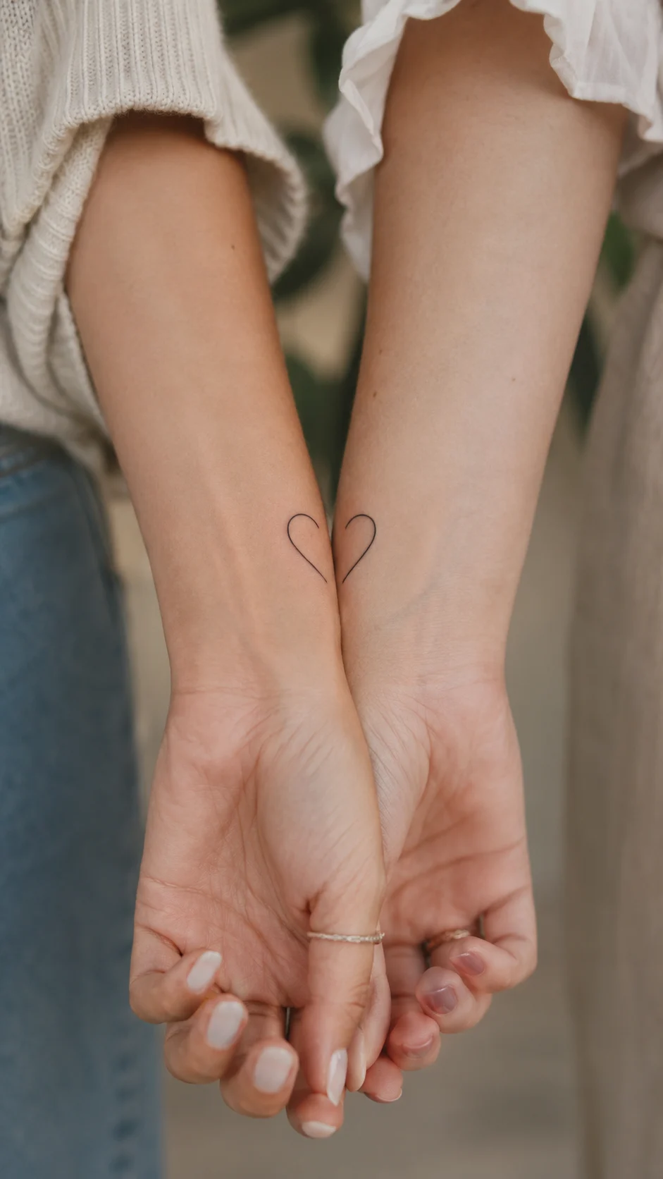 Antebraços com tatuagens discretas de coordenadas e uma data.