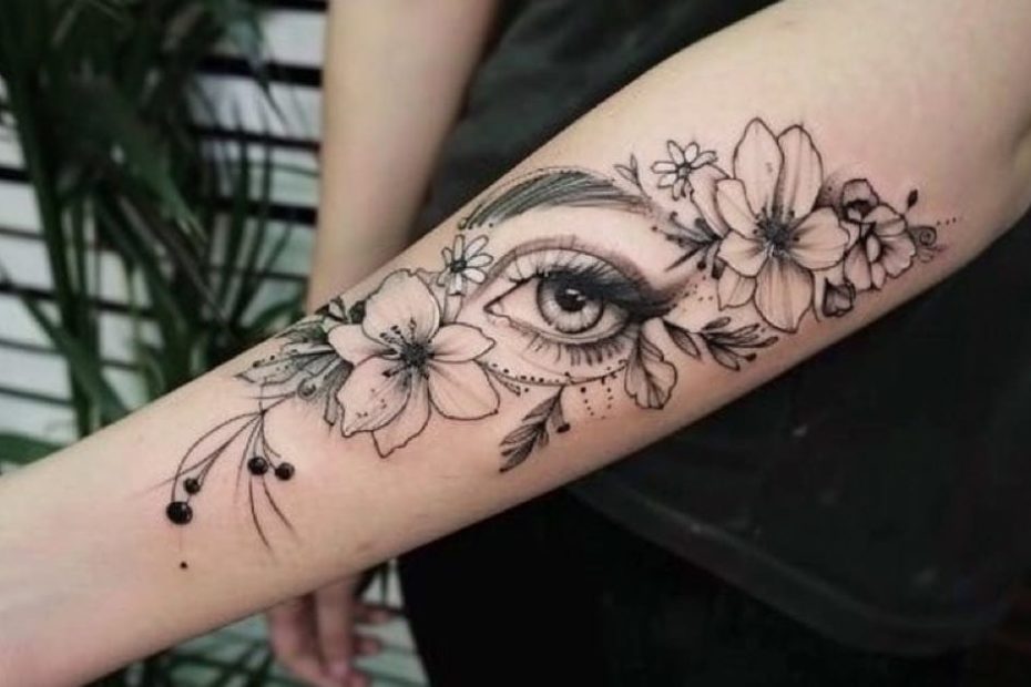 Tatuagem feminina no braço com olho e flores em estilo fino e detalhado.