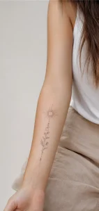 Mulher com tatuagem delicada de antebraço interno em estilo fine line