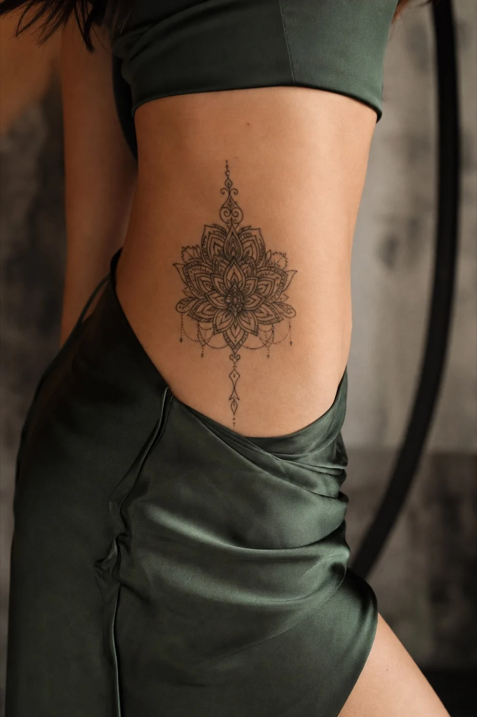 Tatuagem feminina no quadril com mandala ornamental delicada