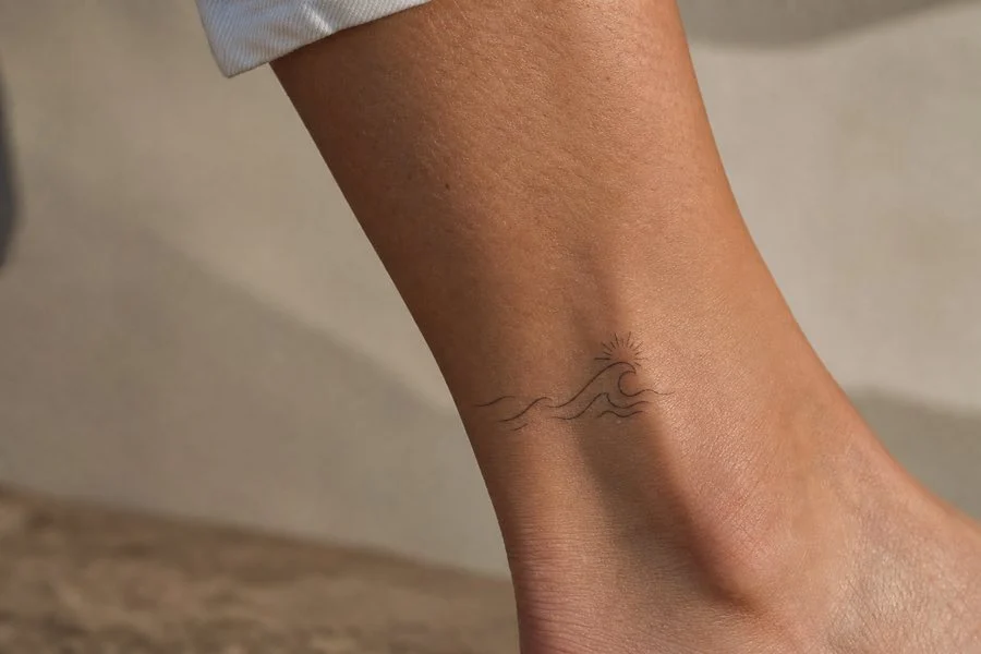 Tatuagem feminina no tornozelo com lua e estrela minimalistas
