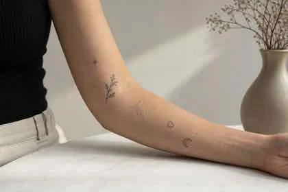 tatuagem patchwork feminina cicatrizada com desenhos pequenos no antebraço
