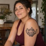 Bule vintage em preto e cinza tatuado no braço de mulher adulta
