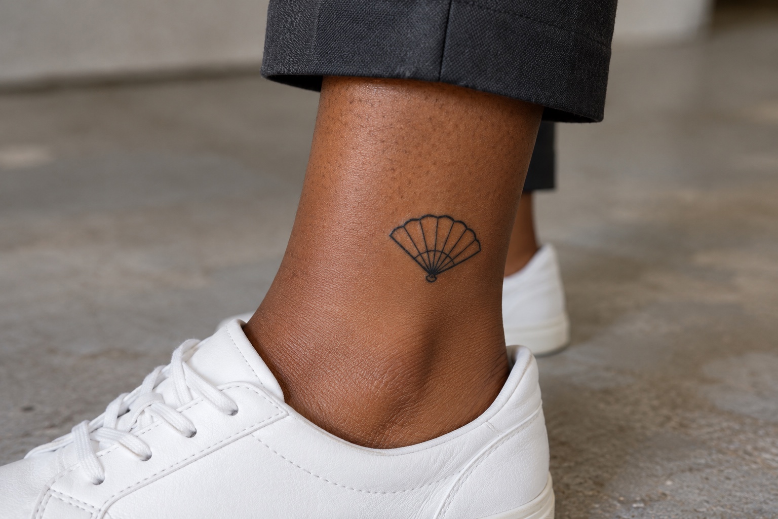 Leque pequeno de linhas pretas tatuado acima do tornozelo de mulher adulta